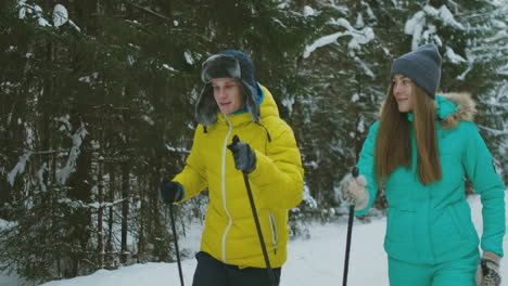 Slow-motion-shot-of-a-loving-couple-skiing-in-the-woods-on-the-eve-of-Valentine's-day